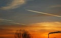 Three airplains flying in the sunset.