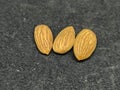 Three almond against black background