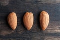 Three almonds on wooden table closup