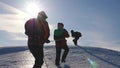 Three Alpenists climb rope on snowy mountain. Tourists work together as team shaking heights overcoming difficulties