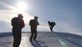 Three Alpenists climb rope on snowy mountain. Tourists work together as team shaking heights overcoming difficulties