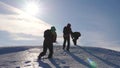 Three Alpenists climb rope on snowy mountain. Tourists work together as team shaking heights overcoming difficulties