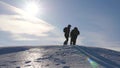 Three Alpenists climb rope on snowy mountain. Tourists work together as team shaking heights overcoming difficulties