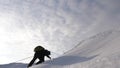 Three Alpenists in winter climb rope on mountain. Travelers climb rope to their victory through snow uphill in a strong
