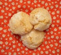 Three amaretti cookies placed on a bright red fabric with a small white and yellow floral pattern Royalty Free Stock Photo