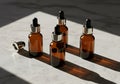Three amber glass dropper bottles arranged on light textured surface with cap Royalty Free Stock Photo