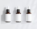 Three Amber Glass Essential Oil Bottles with Droppers on White Surface Royalty Free Stock Photo