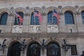 Three American flags hanging above the entrance doors of the Central Boston Public Library