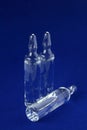 Ampoules of glass with vaccine photographed in blue background