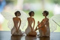 Three angel figure dolls with wings on wooden table