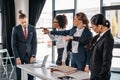 Three angry young businesswomen pointing with fingers at upset businessman in office Royalty Free Stock Photo