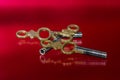 Three Antique Brass Pocket Watch Keys Laying on Red Surface Royalty Free Stock Photo