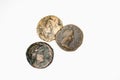 Three antique coins with portraits on a white background