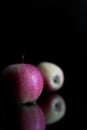 Three apples with drops of water. on a black background. Royalty Free Stock Photo