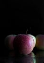 Three apples with drops of water. on a black background. Royalty Free Stock Photo