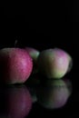 Three apples with drops of water. on a black background. Royalty Free Stock Photo