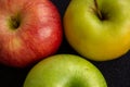 Three apples, one green and two red and yellow on a dark background Royalty Free Stock Photo