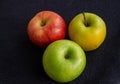 Three apples, one green and two red and yellow on a dark background Royalty Free Stock Photo