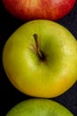 Three apples, one green and two red and yellow on a dark background Royalty Free Stock Photo