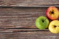 Three apples (red, green, and yellow) on wooden table, top view, copy space Royalty Free Stock Photo