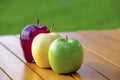Three apples on a table red yellow and green Royalty Free Stock Photo