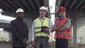 Three architects in protective helmets looking at camera Royalty Free Stock Photo