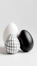 Three artistic eggs: white, black, and grid patterned decoration on white background. Easter, Pascha, Paskha, Ostern Royalty Free Stock Photo