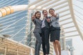 Three business women doing hand as a symbol standing smiling in modern city Royalty Free Stock Photo