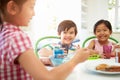 Three Asian Children Having Breakfast Together In Kitchen