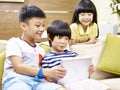 Three asian children playing with digital tablet Royalty Free Stock Photo