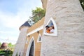 Three asian kids show their head through castle's tower in the s