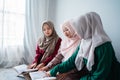 Three asian moslem woman read and learn the holy book of the Al-Quran together