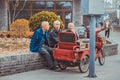 Three asian old men sitting on side walk in street of Beijing