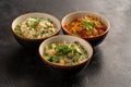 Three Asian side dishes in round bowls of rice, egg noodles, glass noodles and vegetables. Pan-Asian and Asian food and dishes on Royalty Free Stock Photo