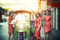 Three asian woman wearing chinese traditon clothes standing beside tuktuk in yaowaratch road chinatown bangkok thailand