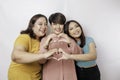 Three Asian women feel happy and a romantic shapes heart gesture expresses tender feelings, close friendship concept