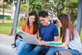 Three Asian young campus students enjoy tutoring and reading boo Royalty Free Stock Photo