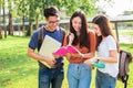 Three Asian young campus students enjoy tutoring and reading boo