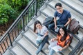 Three Asian young campus students enjoy tutoring and reading boo Royalty Free Stock Photo