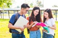 Three Asian young campus students enjoy tutoring and reading books together. Friendship and Education concept. Campus school and Royalty Free Stock Photo
