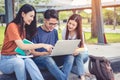 Three Asian young campus students enjoy tutoring and reading books together. Friendship and Education concept. Campus school and Royalty Free Stock Photo