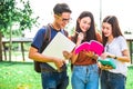 Three Asian young campus students enjoy tutoring and reading books together. Friendship and Education concept. Campus school and Royalty Free Stock Photo