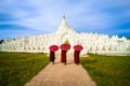 Three Asian young monk holding red umbrellas on the Mya Thein Ta Royalty Free Stock Photo