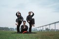 Three Asians wearing pencak silat uniforms with formations