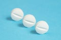 Three aspirin tablets on a blue background Royalty Free Stock Photo