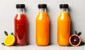 Three assorted fresh fruit juices in glass bottles with black caps on a neutral background, representing healthy dietary Royalty Free Stock Photo