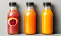 Three assorted fresh fruit juices in glass bottles with black caps on a neutral background, representing healthy dietary Royalty Free Stock Photo