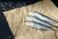 Three Atlantic herrings on craft paper.