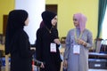 Three attractive Muslim girls communicating in a lobby of Woman International Forum