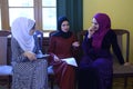 Three attractive Muslim girls communicating in a lobby of Woman International Forum